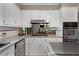 Clean kitchen featuring stainless steel appliances, light countertops, and white cabinets at 9295 Martin Rd, Roswell, GA 30076
