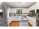 Bright kitchen with stainless steel appliances, white cabinets, and center island for ample cooking space at 9295 Martin Rd, Roswell, GA 30076