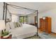 Main bedroom with a four-poster bed, hardwood floors, and a door to a private balcony at 9295 Martin Rd, Roswell, GA 30076