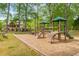 Community playground featuring swings, slides, and climbing structures, with a home visible in the background at 9295 Martin Rd, Roswell, GA 30076