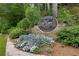 Community entrance sign for Martin's Landing surrounded by flowers, greenery, and a stone wall at 9295 Martin Rd, Roswell, GA 30076