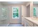 Bright bathroom featuring a glass shower, window, and vanity with white cabinets at 166 Bluffington Way, Marietta, GA 30066