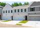 Charming townhouse with brick accents, a two-car garage, and well-maintained landscaping at 166 Bluffington Way, Marietta, GA 30066