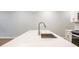 Spacious kitchen island with stainless steel sink, light-colored granite counter top, and designer faucet at 166 Bluffington Way, Marietta, GA 30066