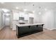 Modern kitchen with black island, white cabinets, stainless steel appliances, and pendant lighting at 166 Bluffington Way, Marietta, GA 30066