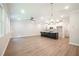 Bright, open-concept living room with wood floors and stylish light fixtures adjoining modern kitchen at 166 Bluffington Way, Marietta, GA 30066