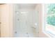A glass-enclosed shower with a built-in seat and a window at 166 Bluffington Way, Marietta, GA 30066