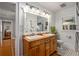 Bright bathroom featuring a double sink vanity, a large mirror, a window with shutters, and black and white tile floor at 1763 Delaware Ne Ave, Atlanta, GA 30307