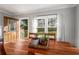 Sunlit dining room featuring hardwood floors, wooden table and chairs, a wooden door, and a view of the backyard at 1763 Delaware Ne Ave, Atlanta, GA 30307