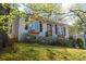 Bungalow with painted gray brick and black shutters with a naturally landscaped hillside at 1763 Delaware Ne Ave, Atlanta, GA 30307