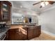 A kitchen island features granite countertops and a gas stovetop with dark brown cabinets and an open concept view to the living room at 1763 Delaware Ne Ave, Atlanta, GA 30307