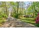 Long driveway leading to a brick home surrounded by lots of green trees at 2680 Irene Dr, Marietta, GA 30066
