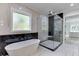 Stunning bathroom featuring marble tile, soaking tub, and glass-enclosed shower, creating a luxurious spa-like experience at 409 Thunder Rd, Buford, GA 30518