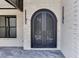 Close-up of the front door with an iron design, brick siding, and modern lighting fixtures at 409 Thunder Rd, Buford, GA 30518