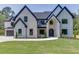 Elegant two-story home featuring a well-manicured front lawn, stone accents, and classic architectural details at 409 Thunder Rd, Buford, GA 30518