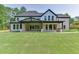 Back exterior view of the home with a covered patio and expansive backyard at 409 Thunder Rd, Buford, GA 30518