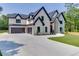 A beautiful two-story home featuring a three-car garage, manicured lawn, and classic architectural details at 409 Thunder Rd, Buford, GA 30518