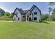 Elegant two-story home featuring a well-manicured front lawn, stone accents, and classic architectural details at 409 Thunder Rd, Buford, GA 30518