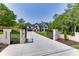 Elegant two-story home with a black gated entrance, long driveway, and professionally landscaped front yard at 409 Thunder Rd, Buford, GA 30518