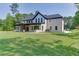 Exterior view of a white brick home with covered patio and sprawling lawn at 409 Thunder Rd, Buford, GA 30518