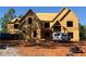 An in-progress build of a large, two-story home with wood framing and a prominent gable roof design at 409 Thunder Rd, Buford, GA 30518