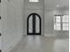 Elegant foyer with detailed millwork, arched doorway, white walls, and light wood-look floors at 409 Thunder Rd, Buford, GA 30518