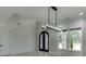 Bright foyer features decorative accent wall, black double doors, light hardwood floors, and a modern chandelier at 409 Thunder Rd, Buford, GA 30518