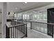 Open hallway with view of living room and staircase featuring black metal railings at 409 Thunder Rd, Buford, GA 30518