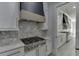 A detailed shot of the kitchen with gas cooktop, marble backsplash, and modern range hood at 409 Thunder Rd, Buford, GA 30518