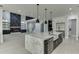 Open kitchen featuring a marble island, stainless steel appliances, and a living area with a fireplace at 409 Thunder Rd, Buford, GA 30518