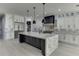 A modern kitchen boasts a large island, stainless steel refrigerator, granite countertops, custom cabinets, and stylish pendants at 409 Thunder Rd, Buford, GA 30518