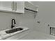 Laundry room has a marble countertop, stainless steel sink, black faucet and white shaker cabinets at 409 Thunder Rd, Buford, GA 30518