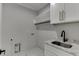 This laundry room features marble floors and countertops plus a sink and white cabinets at 409 Thunder Rd, Buford, GA 30518