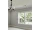 This well-lit living room features two large windows looking out to the lush tree line at 409 Thunder Rd, Buford, GA 30518