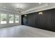 Open living room features large windows, a modern chandelier and black accent wall at 409 Thunder Rd, Buford, GA 30518