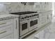 Close-up of a large stainless steel oven with marble countertops and white cabinets at 409 Thunder Rd, Buford, GA 30518