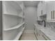 Walk-in pantry with open shelves, a farmhouse sink, marble countertops, and white cabinetry at 409 Thunder Rd, Buford, GA 30518