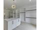 Walk-in closet featuring custom shelving, a central island with marble countertop, and a modern light fixture at 409 Thunder Rd, Buford, GA 30518
