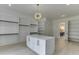 Large walk-in closet featuring custom shelving, central island with marble countertop, and access to the ensuite bathroom at 409 Thunder Rd, Buford, GA 30518