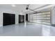Spacious garage with epoxy floors, black interior doors, and a modern glass panel garage door at 676 S Grand Nw Ave, Atlanta, GA 30318