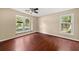 This bedroom features hardwood floors, a ceiling fan, and natural light from large windows at 2605 Vineyard Se Way, Smyrna, GA 30082