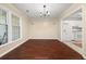 This dining room features hardwood floors, a modern chandelier, and natural light from large windows at 2605 Vineyard Se Way, Smyrna, GA 30082