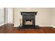 Living room's black fireplace with decorative mantel and tool set on hardwood floors at 2605 Vineyard Se Way, Smyrna, GA 30082