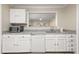 Galley kitchen with white cabinetry, granite counters, stainless microwave, and view into dining area at 2605 Vineyard Se Way, Smyrna, GA 30082