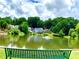Scenic view of the community pond with a fountain, surrounded by lush trees and charming homes at 2605 Vineyard Se Way, Smyrna, GA 30082