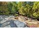 Landscaped backyard with fire pit, mature trees, and stone accents at 265 Tara Trl, Atlanta, GA 30327