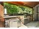 Outdoor kitchen features stone surround, stainless grill, and stone paver floor at 265 Tara Trl, Atlanta, GA 30327