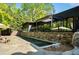 Backyard oasis featuring a sleek lap pool, stone patio, and shaded outdoor living area at 265 Tara Trl, Atlanta, GA 30327