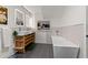 Bright bathroom featuring double sinks with a modern vanity, a soaking tub, and stylish gray tile floors at 3143 Church St, East Point, GA 30344