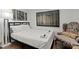 Modern bedroom with a plush bed, dark frame artwork, unique chair, and hardwood floors at 3143 Church St, East Point, GA 30344